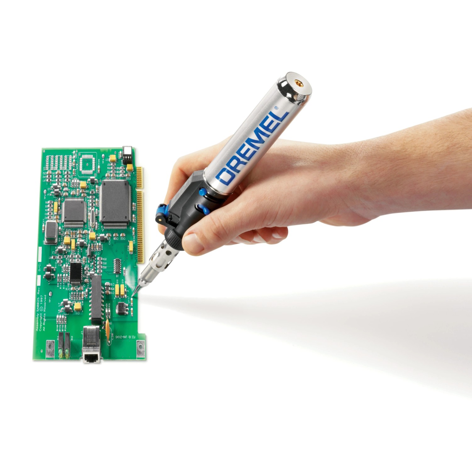 Dremel VersaTip forrasztópáka működés közben: Kéz forraszt áramköri lapot miniatűr szerszámmal. Dremel VersaTip forrasztópáka működés közben: Kéz forraszt áramköri lapot miniatűr szerszámmal.