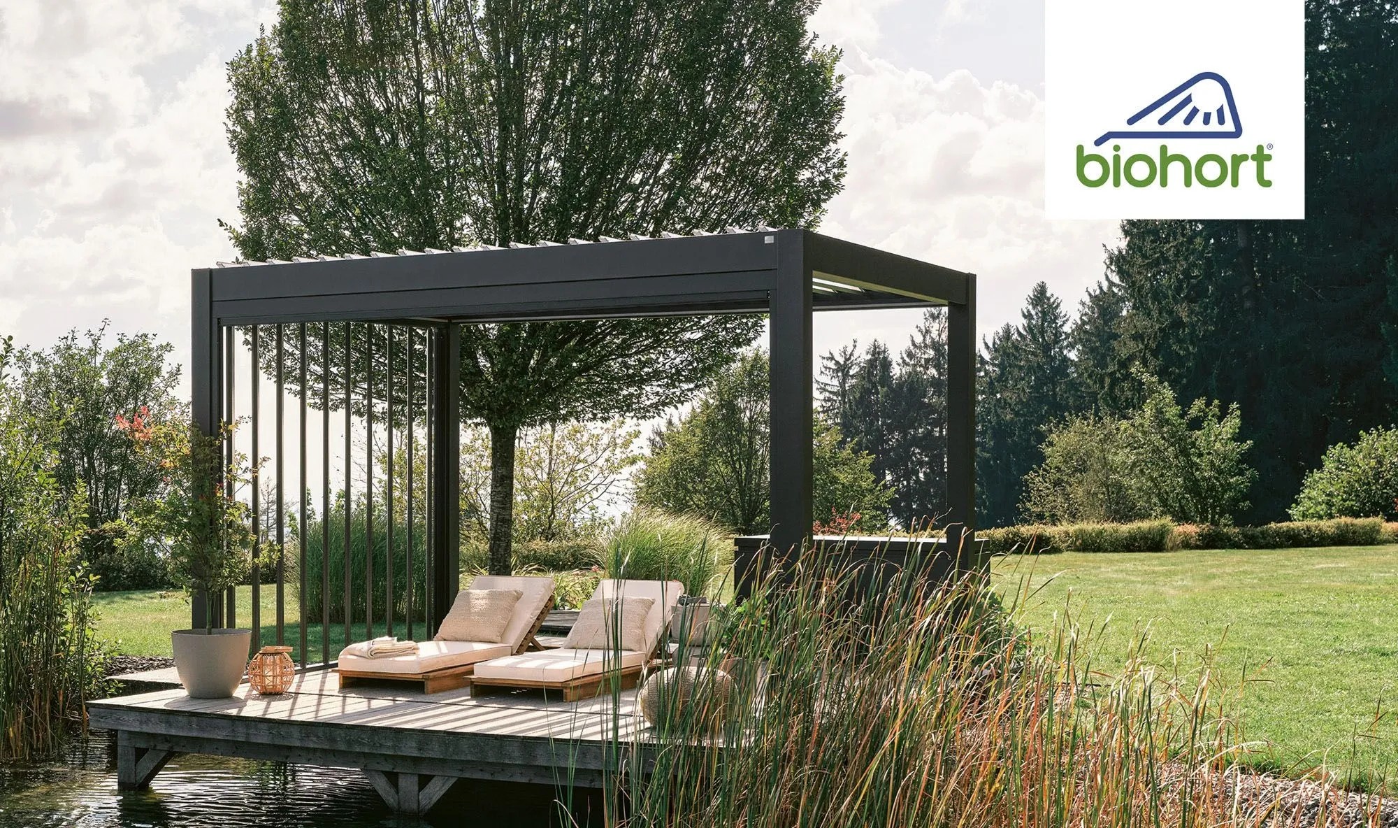 Biohort Pergola 4,5x3,5 m kvarc fehér színben, fa teraszon, két nyugággyal a kertben. Biohort Pergola 4,5x3,5 m kvarc fehér színben, fa teraszon, két nyugággyal a kertben.