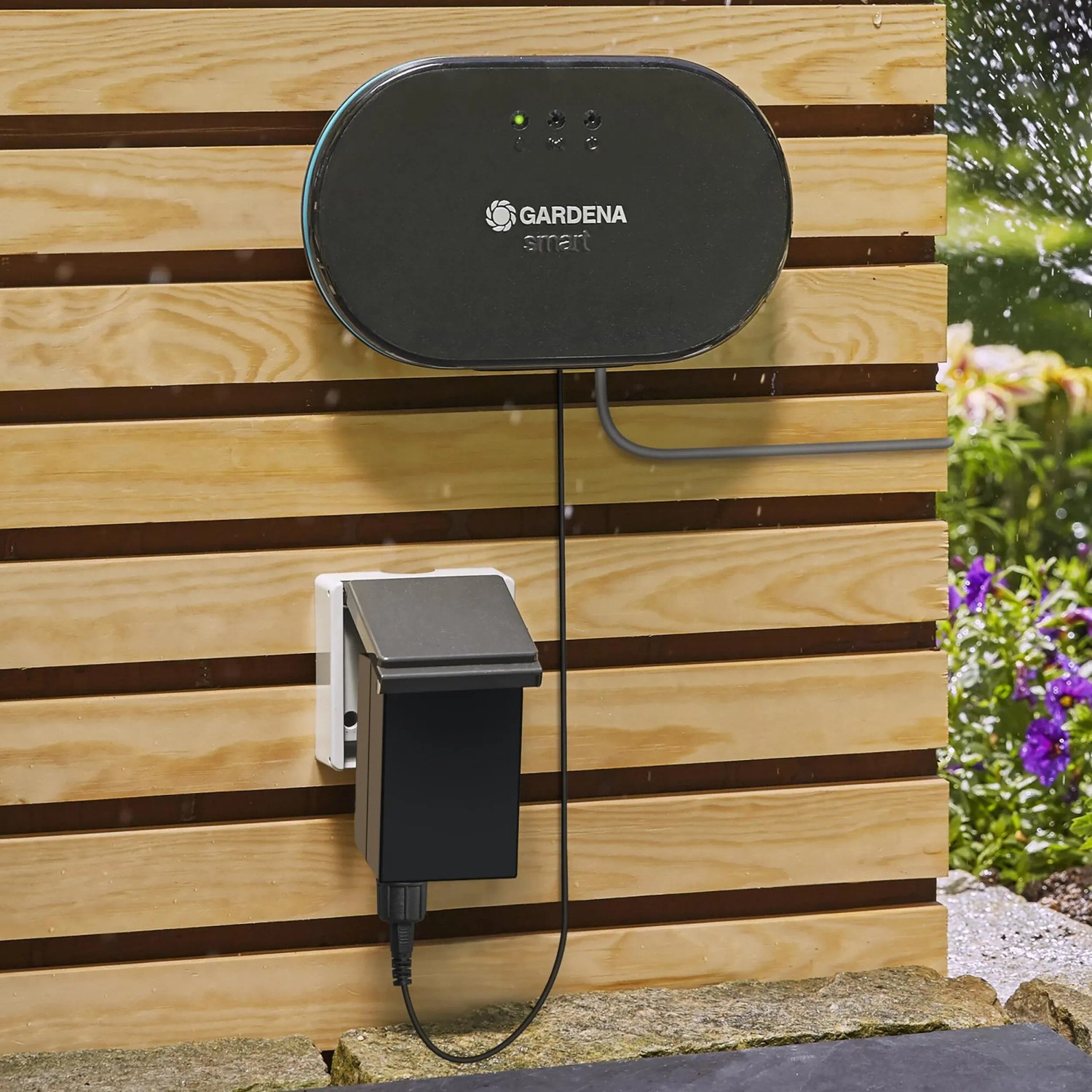 Gardena smart Irrigation Control többcsatornás vezérlés fa falon, öntözéssel a háttérben. Gardena smart Irrigation Control többcsatornás vezérlés fa falon, öntözéssel a háttérben.