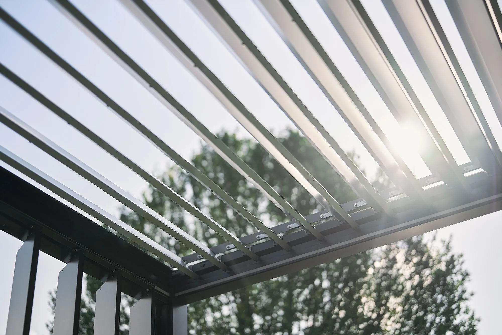 Biohort Pergola, 4,5x3,5 m, kvarc fehér, nyitott lamellák, alulról az ég felé nézve. Biohort Pergola, 4,5x3,5 m, kvarc fehér, nyitott lamellák, alulról az ég felé nézve.