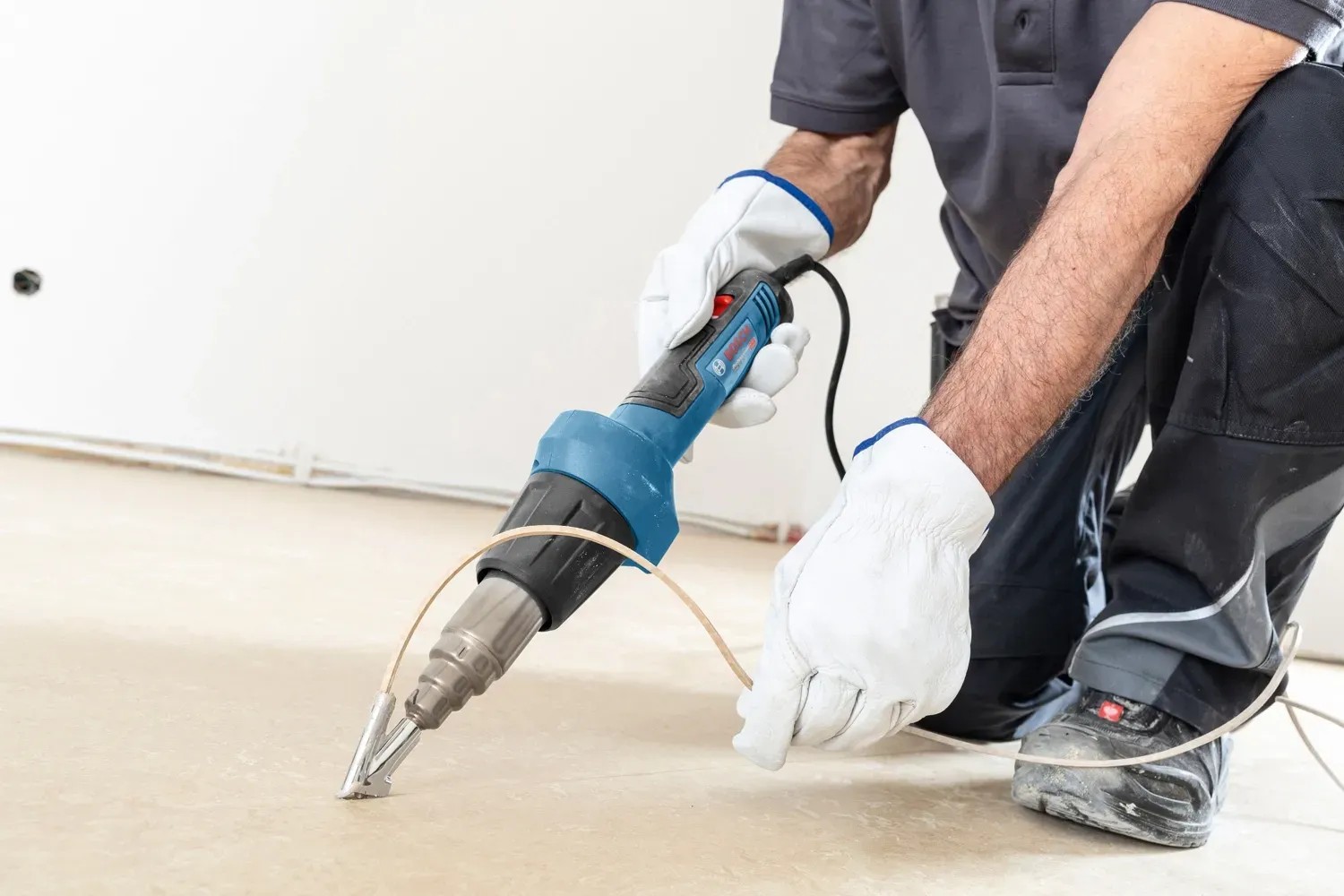 Bosch Professional GHG 20-60 hőlégfúvó padlóburkolat eltávolítás közben. Bosch Professional GHG 20-60 hőlégfúvó padlóburkolat eltávolítás közben.