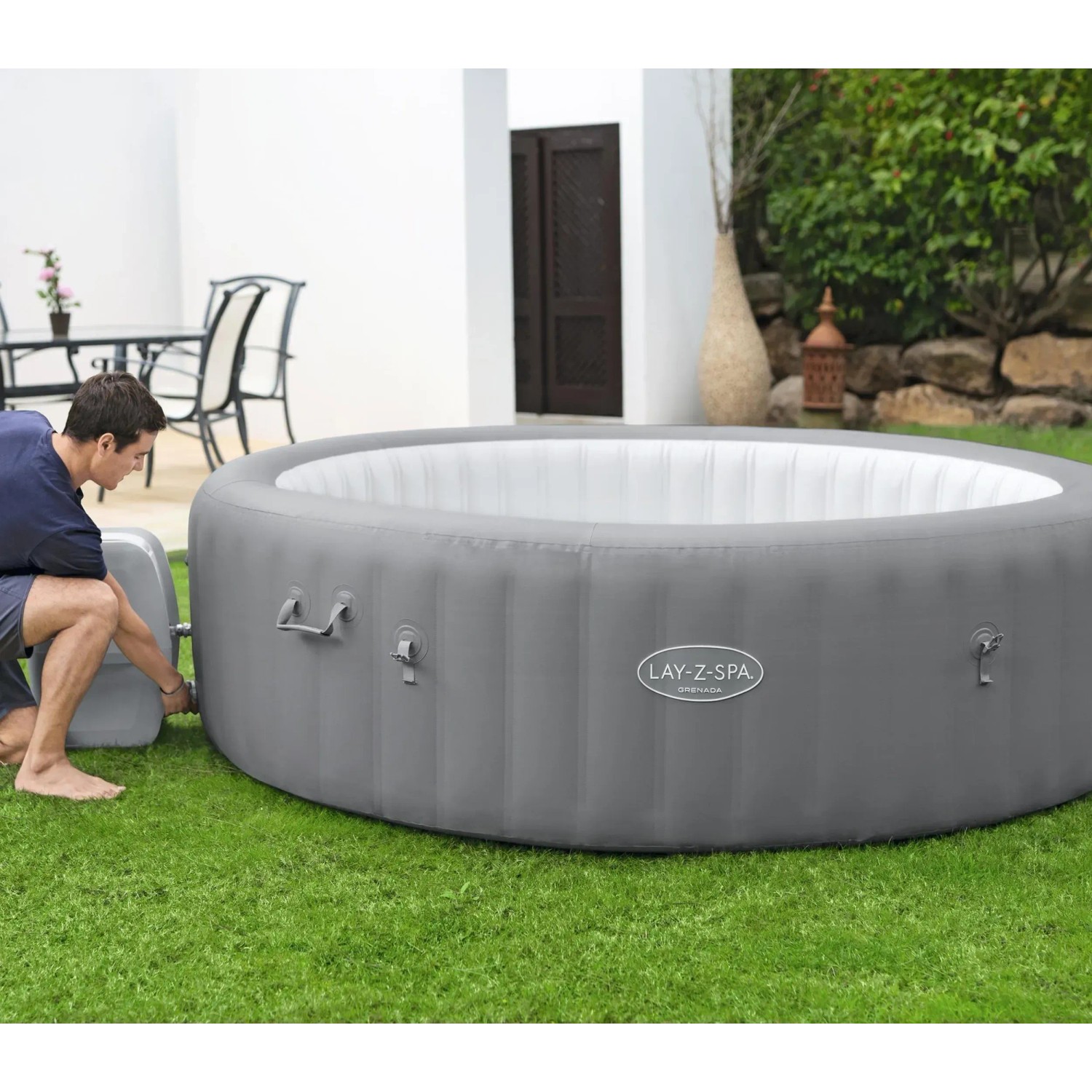 Bestway Lay-Z-Spa Grenada AirJet, felfújható pezsgőfürdő világosszürke színben, Ø 236 cm, egy férfi éppen felállítja. Bestway Lay-Z-Spa Grenada AirJet, felfújható pezsgőfürdő világosszürke színben, Ø 236 cm, egy férfi éppen felállítja.