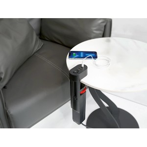 Fekete 3-as elosztó USB portokkal az asztalhoz rögzítve, egy okostelefon töltődik.
