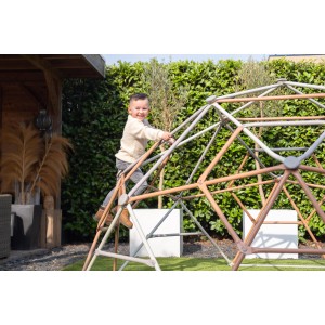 Gyermek mászik az Exit Metal Climbing Dome Ø 300 cm mászókupolán a kertben.