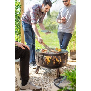 Buschbeck Wildfire tűzrakóhely grill funkcióval használatban, emberek grilleznek.