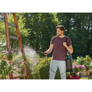 Férfi használja a Gardena Comfort 5 l nyomáspermetezőt növényápolásra a kertben.