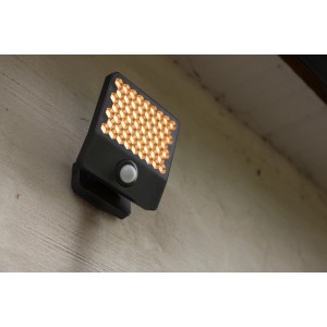 Fekete LED-es kültéri fali lámpa mozgásérzékelővel és méhsejt alakú fényfelülettel.