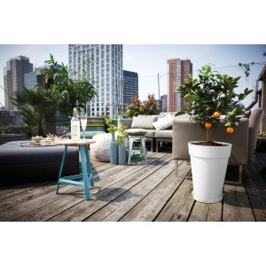 Fehér, magas Elho Loft Urban virágcserép (Ø 35 cm) narancsfával egy tetőteraszán.