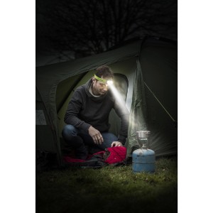Férfi kempingezik Energizer Vision HD+ LED fejlámpával sátor és lámpa előtt.
