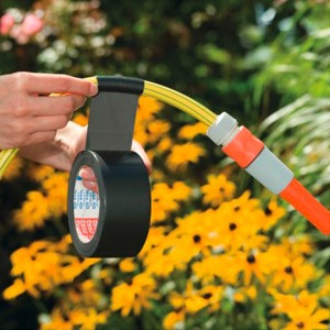 Fekete Tesa Extra Power Universal szalag egy kerti tömlő javításához.