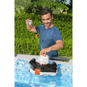 Férfi helyezi a Flowclear Aquarover medence robotot a vízbe. Automatikus medencetisztítás a tiszta vízért.