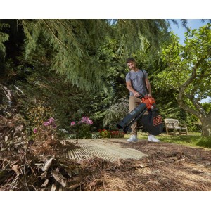 Black+Decker BCBLV36B akkus lombfúvó használat közben: Férfi leveleket szív fel a kertben. Kompakt, vezeték nélküli eszköz.