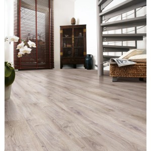 Kaindl Comfort 7 mm-es laminált padló természetes tölgy színben egy nappaliban, világos fa hatás.
