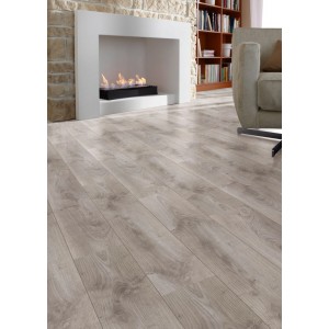 Kaindl Comfort 7 mm London tölgy laminált padló fa erezettel, modern nappaliban kandallóval és kanapéval.