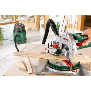 Bosch PCM 7 gérvágó fűrész használat közben, háttérben porelszívóval.