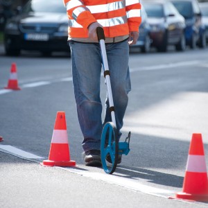Bosch Professional GWM 32 mérőkerék használat közben az úton, építési terület felmérése.