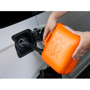 Narancssárga OBI üzemanyag kanna (5 l) autó tankolás közben.