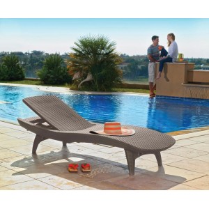 Barna rattan kerti nyugágy kalappal és szandállal a medence mellett. Tiszta kikapcsolódás!