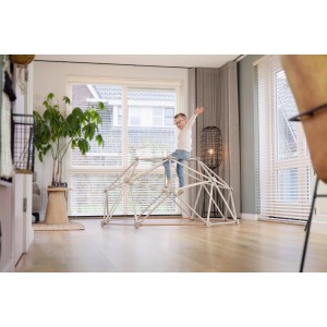 Exit Metal Climbing Dome (Ø 190 cm) egy nappaliban, ahol egy gyermek mászik rajta.