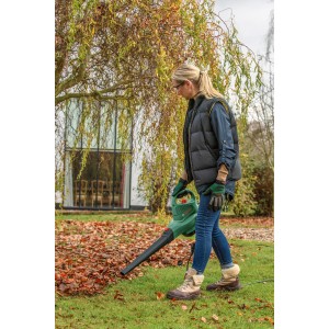 Nő használja a Bosch UniversalGarden Tidy 2300 kerti porszívót a levelek összegyűjtésére.
