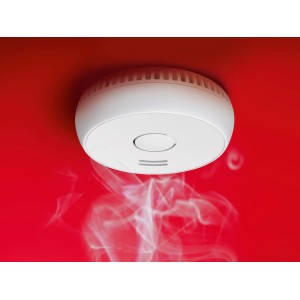 Fehér fotoelektromos füstérzékelő piros mennyezeten füsttel. Tűzvédelem otthonába.