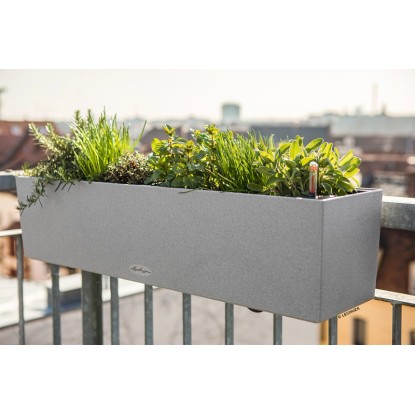 Lechuza Balconera Stone 80, kőszürke virágláda növényekkel egy erkélyen.