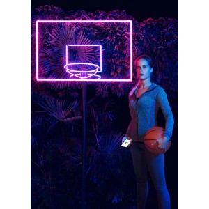 Nő kosárlabdával a megvilágított Osram LED szalag neon kosárlabda palánk előtt.