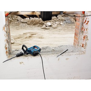 Bosch Professional GSH 5 bontókalapács vésővel egy falnyílás előtt.