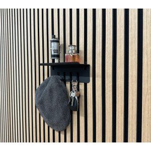 Fekete FN Acustico kulcstartó kulcsokkal, kalappal és dekorációval akusztikus panel falon.