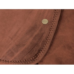 Közelkép egy szürke (3 mm) szegecsről barna bőrön, ideális textil dekorációhoz.