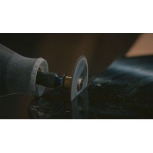Dremel forgószerszám EZ SpeedClic vágókoronggal, precízen vág egy sötét felületet.