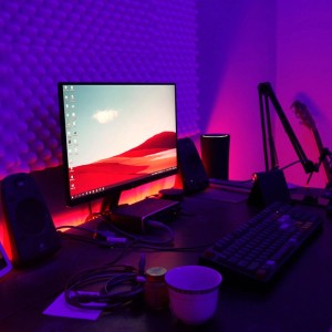 Íróasztal RGB LED szalaggal a monitor mögött, hangulatos világítást teremtve.