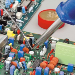 LUX 30 W-os forrasztópáka készlet forrasztás közben egy elektronikus alkatrészekkel ellátott áramköri lapon.