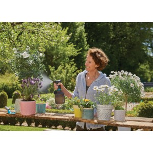 Nő használja a Gardena EasyPump 1 l-es pumpás permetezőt növények öntözésére a kertben.