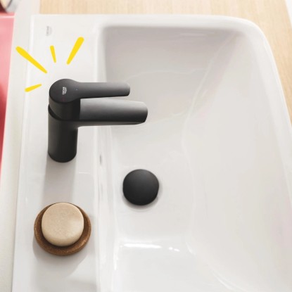Fekete Grohe QuickFix Start S mosdó csaptelep fehér mosdókagylón.