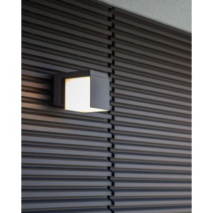 Modern Lutec Cuba antracit LED kültéri fali lámpa meleg fehér fénnyel sötét fa falon.