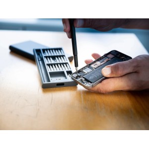 LUX okostelefon javítókészlet (26 részes) egy mobiltelefon javításakor.