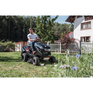 Fekete Al-Ko benzines fűnyíró traktor Easy 15-93.2 HD-A fűnyírás közben a kertben.
