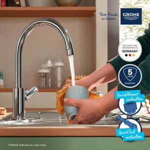 Grohe QuickFix Start Edge egykaros króm mosogató csaptelep magas kifolyóval, éppen egy csészét tölt meg.