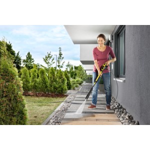 Nő tisztítja a teraszt sárga Kärcher K 4 Power Control Flex magasnyomású mosóval.