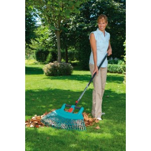Nő gereblyézi a leveleket a kertben Gardena combisystem-ergoline alumínium nyéllel, 130 cm-es.