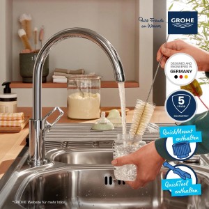 Grohe QuickFix Start Loop króm konyhai csaptelep, amint egy cumisüveget tisztít a mosogatóban.