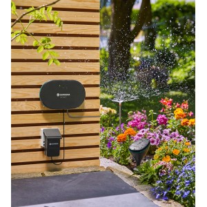 Gardena smart Irrigation Control öntözőkomputer érzékelővel és szórófejjel a kertben.