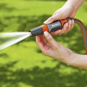 Gardena tisztító szórófej használat közben: vízsugár a kert tisztításához.