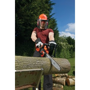 Férfi fát vág Black+Decker akkus láncfűrésszel, sisakot és arcvédőt visel.