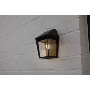 Fekete LED kültéri fali lámpa fehér téglafalon.