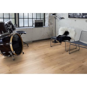 Kaindl Excellent laminált padló 8 mm Eiche Ferrara Beachlin lerakva egy modern nappaliban, dobfelszereléssel.