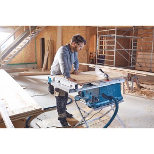 Bosch Professional GTS 635-216 asztali körfűrész használat közben kezelővel és munkadarabbal.