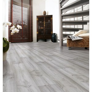 Lerakott Kaindl Masterfloor 8 mm Laminált Tölgy Szürke nappaliban fa szekrénnyel és csigalépcsővel.