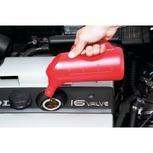 Piros LUX mérőkanna (1000 ml) olajat önt egy motorba.